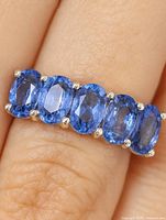 Ring on finger showing five oval tanzanite stones