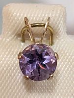 Front view of pendant on display card showing round amethyst and prong setting