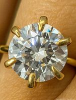Close-up of round moissanite in six-prong yellow gold setting