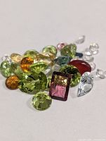 Group of multicoloured faceted gemstones on white background