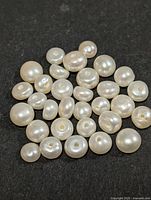 group of loose drilled pearls on black background