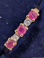 Close-up of gemstone setting showing three rubies and two diamonds