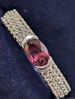 Top view of silver ring showing oval red stone and pavé shoulders