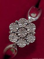Top view showing 7-stone diamond cluster on silver band