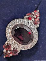 top view of ring showing garnet, CZ halo and side stones