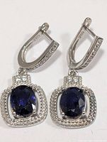 Front view of both earrings showing blue center stones and silver settings