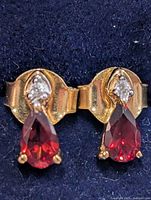 Front view of both earrings showing garnet drops and accent stones