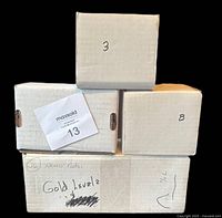 Four labelled cardboard card boxes photographed closed