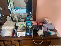 Overview of all items on dresser including blood pressure monitor, heating pad box, soap, razor blades, wax strips and more