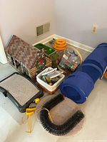 Group view of cat tunnel, cardboard house, scratching pads, toys, baskets