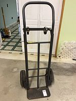 Full front view of hand truck showing frame, D-handle, toe plate