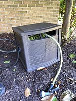 Suncast plastic reel box with hose protruding