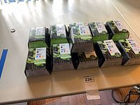 Tabletop view of 12 sealed HP 902/902XL ink cartridge boxes