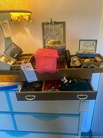 Full view of open drawer with jewelry box, cases, jewelry pieces