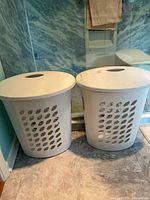 Pair of white Sterilite hampers with lids shown together