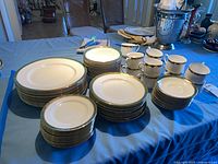 Stacked dinner, salad and bread plates, bowls, cups and saucers on table