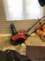 Full view of Toro snow blower with cover and wheelchair parts nearby