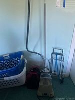 Garment steamer, two plastic laundry baskets, collapsible hamper and folding luggage cart grouped together