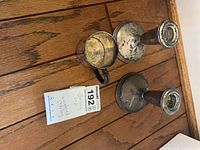 Top view of baby cup and two candleholders on wood surface
