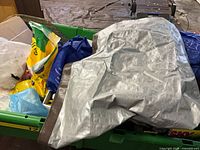 Silver tarp, potting mix bag, blue bags visible in green bin