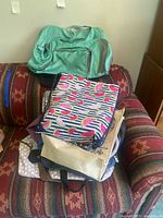 Stack of assorted bags on couch