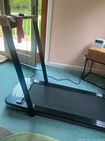 Full view of treadmill left side showing slim frame and attached power cord