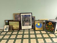 All framed artworks lined against wall