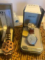 Seiko box with Seiko round watch, rectangular gold-tone watch plus Gruen 14k, Jalga wood watch visible