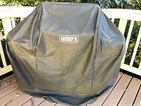 Weber branded black vinyl cover over grill
