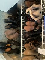 Overview of boots and slippers on wire shelf and floor