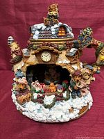 Front view showing full teapot figure with snowy cottage and bears