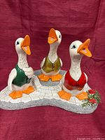 Front view of full duck trio figurine on base
