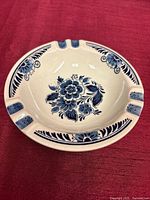 Top view of ashtray showing blue floral design and three rests