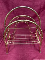 Front view of brass-tone metal magazine rack