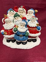 Front view of multicolor plaster sculpture with eight Santa figures