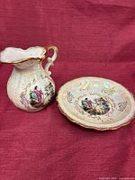 Pitcher and saucer together on red cloth