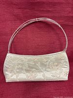 Front view of ivory beaded evening clutch showing bead and sequin floral design and double-strand beaded strap