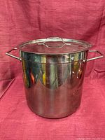 Front view of stock pot with lid on showing polished exterior and side handles