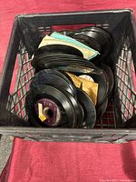Milk crate containing stack of 7-inch records