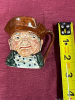 Front view with tape measure showing height and detailed face