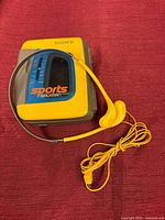 Front view showing yellow cover, blue tuner window, and earphones