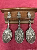 Front view of all three spoons hanging on rack