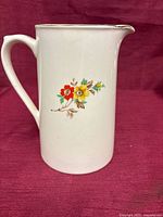 Front view of ivory floral ceramic pitcher