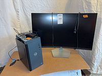 Front view showing Dell curved monitor, desktop tower, mouse and cords