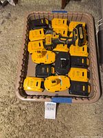 Tray containing eighteen yellow DeWalt battery packs with one black cordless drill