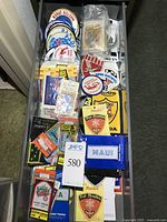 Drawer containing numerous scuba diving patches, packaged and loose