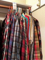 Closet rod with ~25 plaid and solid shirts plus vest on hangers