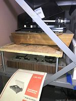 Realistic LAB-420 on lower shelf with owner’s manual visible; Dual 1009 stacked above, both with dust covers