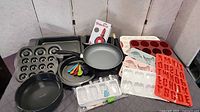 Overview of all bakeware, molds, frying pan, measuring spoons and packaged Starfrit utensil