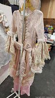 Full front view of pink rococo costume on hanger